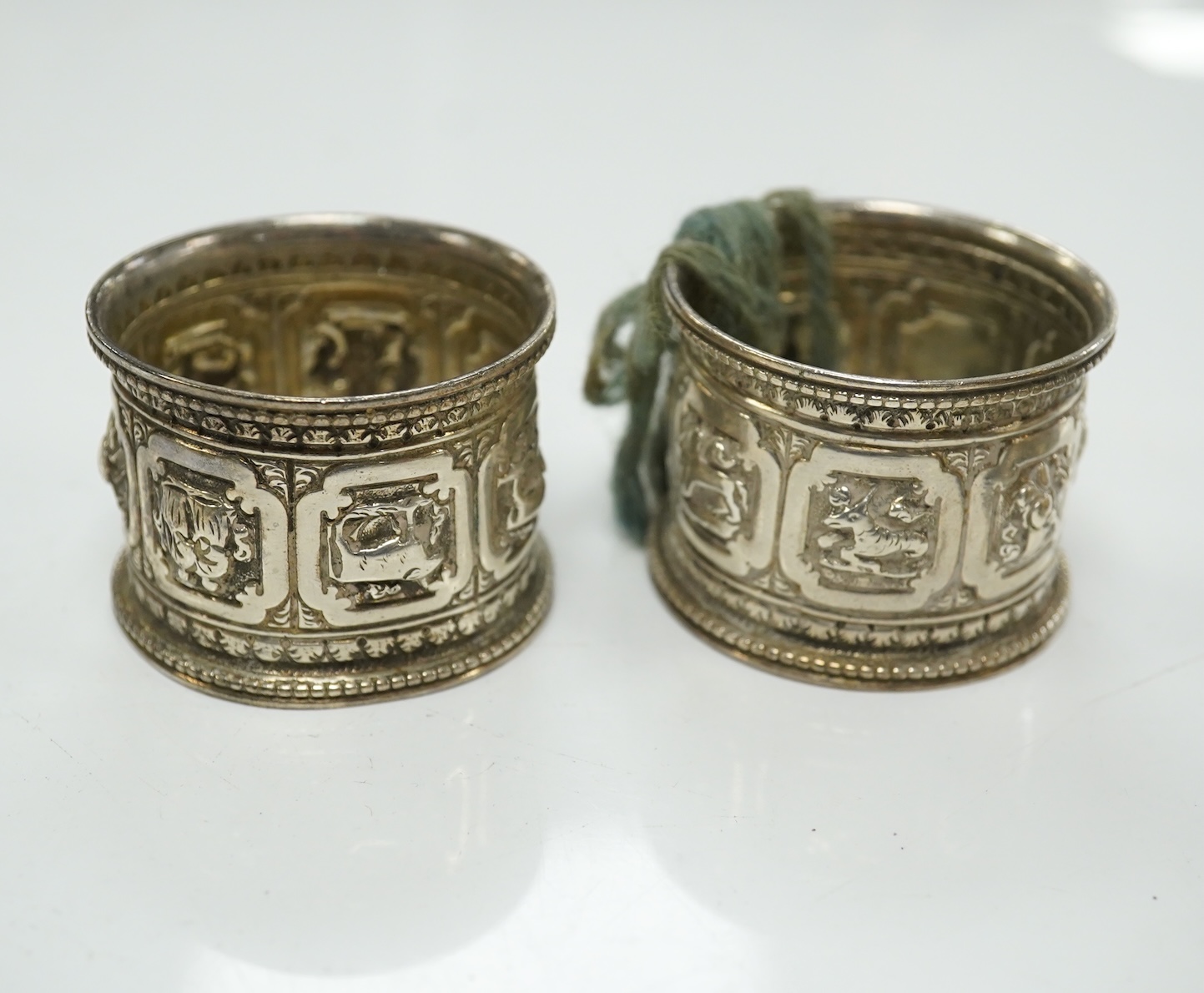 Two pairs of Victorian silver napkin rings and a George III silver wine funnel with later embossed decoration, 14.1cm. Condition - poor to fair